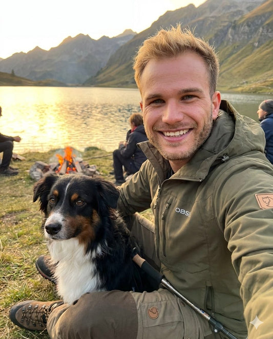 Nils, Gründer von OBSI, am Bergsee mit seinem Hund beim Lagerfeuer